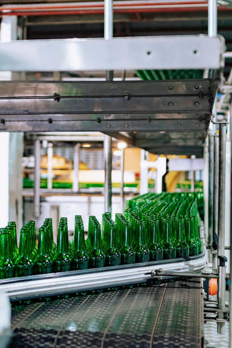 Streamlined glass bottle manufacturing process in factory setting, showcasing assembly line automation.